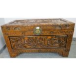 A vintage Chinese export camphorwood trunk, with ornate relief carving depicting sailing junks and