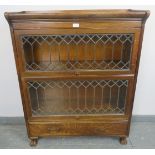 A vintage oak two-section Globe Wernicke style stacking bookcase, with leaded glass doors and drawer