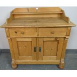 An antique striped pine sideboard with shaped gallery, housing two short drawers and cupboard