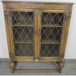A vintage oak glazed bookcase in the 17th century taste, the leaded doors opening onto two