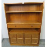 A mid-century teak tall bookcase by Parker Knoll, with one long drawer and cupboard under, on a