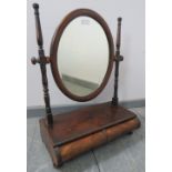 A Georgian flame mahogany oval bevelled swing vanity mirror, with parquetry inlay and turned