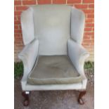 A vintage Georgian style wingback armchair upholstered in a pale green draylon fabric raised on