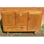 A mid-century elm and beech sideboard by Ercol, housing two cupboards, both with loose shelves,