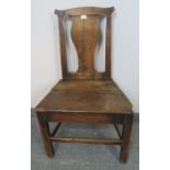 An 18th century elm hall chair with shaped back splat, on inner chamfered square supports with