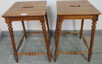 A pair of antique walnut Continental farmhouse stools, with pierced seats, on turned supports united