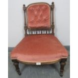 A turn of the century mahogany nursing chair with reeded uprights and finials, upholstered in