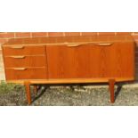 A mid-century teak sideboard by McIntosh, housing three short drawers with scalloped handles and