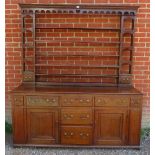 An 18th century English oak dresser with plate-rack over a sideboard base, housing an