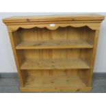An antique style stripped pine low open bookcase of three fixed shelves, flanked by reeded