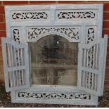 A vintage wall mirror painted distressed blue with foliate carved and pierced surround and arched