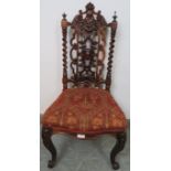 A Victorian rosewood hall chair, the ornately carved and pierced back with barley twist uprights, on