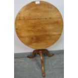 A Georgian elm tilt-top circular wine table, on baluster turned column with splayed tripod base.