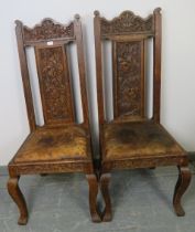 A pair of 19th century Gothic revival oak hall chairs, the ornate relief carving depicting green man
