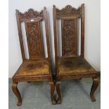 A pair of 19th century Gothic revival oak hall chairs, the ornate relief carving depicting green man