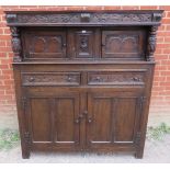 A 19th century oak court cupboard in the 17th century taste, with relief carved frieze and central