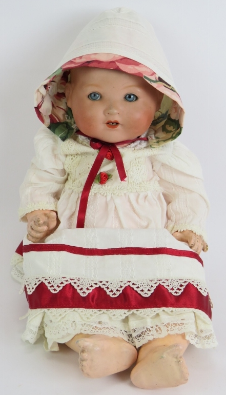 A Bisque headed Armande Marseille baby doll marked AM Germany 351/5k. Cotton and ribbon gown and