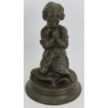 A small European bronze figure of a praying child kneeling on a cushion. Unsigned. Height 23cm.