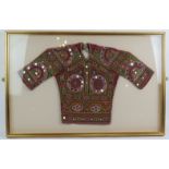 A vintage Asian child's embroidered jacket, mounted and glazed in a box frame. Overall size 82cm x