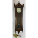 A modern striking wall clock in mahogany case with brass pendulum and weights. Key present.