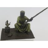 A cold painted bronze figure of an Arab on a carpet in the style of Franz Bergmann. Mark to back.