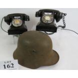 Two vintage black Bakelite telephones, together with a WWII German helmet. Condition report: As
