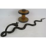 An ornately decorated Benares style brass Cobra wall sconce and a cotton mill spool pipe stand