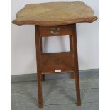 An Arts & Crafts light oak two-tier occasional table, the shaped top with carved and pierced