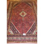 A fine North West Persian Hamadan carpet, central diamond motif on cream ground, set on a deep red