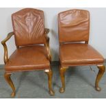 A pair of antique walnut His and Hers desk chairs, one a carver, upholstered in distressed tan