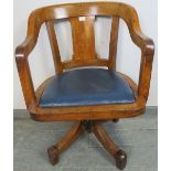 An Edwardian light oak swivel desk chair, with blue rexine seat pad, on four splayed supports.