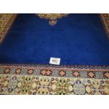 A Moroccan late 20th century wool carpet, central cream motif on a deep blue ground and cream