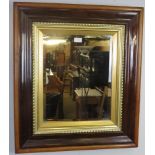 An antique rosewood, walnut and parcel gilt bevelled rectangular wall mirror. Condition report: No