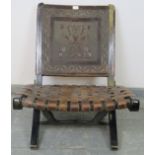 A vintage folding chair by Angel Pazmino of Ecuador, the backrest embossed with an Inca motif, the