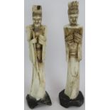 A pair of far eastern carved bone Emperor and Empress figures mounted on carved wood stands. Height: