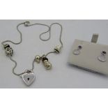 A white metal necklace with six charms, including a snowman and heart, with a lobster clasp and a