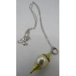 A bespoke Australian Golden Southsea pearl pendant set between planished yellow metal mounts. The
