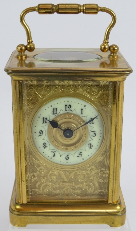 A 19th century gilt brass cased carriage clock with engraved gilt mask and enamelled dial ting.