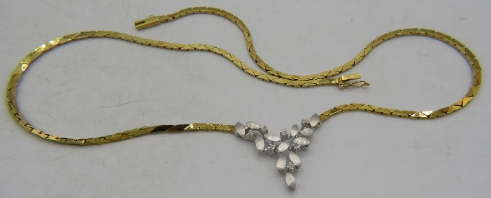 An 18ct yellow & white gold delicate necklace. The centre design having leaf decoration and set with