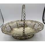 A fine Georgian silver basket with swing handle. Having pierced decoration embossed with scrolls,