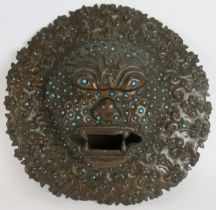 An antique bronze Indian temple mask inset with small blue stones. Believed to be used for warding