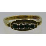 An 18ct yellow gold ring set with four small emeralds, approx weight 5.5 grams. Condition report: