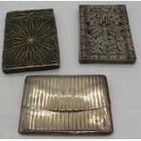 A silver card case with spring hinge, London 1910 and two white metal filigree card cases. Approx