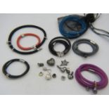 A collection of 7 various wrap around leather, satin and shark skin bracelets with 27 various