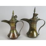 Two antique copper and brass middle Eastern Dallah coffee pots, both intricately decorated.