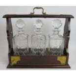 A brass mounted mahogany three decanter tantalus with key. Condition report: Slight staining