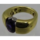 A heavy 18ct yellow gold ring set with centre amethyst, approx 10mm x 8mm. To the top of the ring is