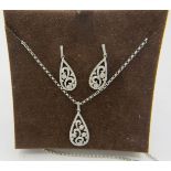 A fine pear shaped 9ct white gold pendant with openwork floral design encrusted with diamonds on a