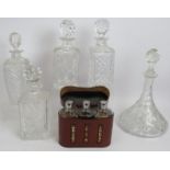 Four cut crystal glass spirit decanters, a similar ships decanter and a vintage leather cased