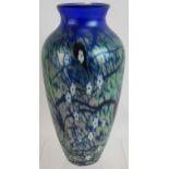 An iridescent blue glass Okra vase decorated with Millefiori type flowers, etched 'Nightshade', R